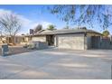 Well-kept single-story home featuring a spacious driveway leading to an attached two-car garage with desert-style landscaping at 3834 E Shaw Butte Dr, Phoenix, AZ 85028