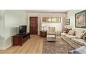 Comfortable living room with wood floors, a brown wooden door, and simple decor at 459 S Boojum Way, Mesa, AZ 85208