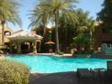 Resort-style pool area with swaying palm trees, comfortable lounge chairs, and a relaxing gazebo at 5335 E Shea Blvd # 1095, Scottsdale, AZ 85254