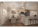 Staged dining room with neutral colors, pendant lighting, and bar stool seating at the kitchen counter at 5345 E Van Buren St # 167, Phoenix, AZ 85008