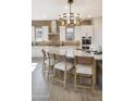 Elegant kitchen boasts a large island with counter seating, designer lighting, and stainless steel appliances at 5719 S Quartz St, Gilbert, AZ 85298