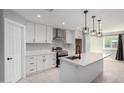 Modern kitchen with stainless steel appliances, white cabinets, a kitchen island, and open to the living space at 700 N D St, Eloy, AZ 85131