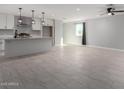 Bright and airy living room featuring neutral paint, tile floors, a modern ceiling fan, and a large window at 700 N D St, Eloy, AZ 85131