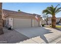 Spacious three-car garage with ample driveway parking, set against a desert landscape at 9 W Glenhaven Dr, Phoenix, AZ 85045