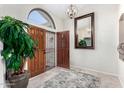 Bright foyer with tile flooring, a large decorative mirror, and views of the arched window at 9809 W Wescott Dr, Peoria, AZ 85382