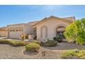Inviting single-story home with desert landscaping, a two-car garage, and arched window details at 9809 W Wescott Dr, Peoria, AZ 85382