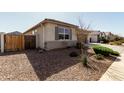 Exterior view of home with gravel landscaping, a wood fence, and shuttered windows at 1039 W Tuli Way, San Tan Valley, AZ 85143