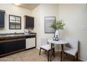 Well-organized kitchen space with coordinated black cabinets, a marble table, and bright neutral decor at 1126 W Elliot Rd # 1024, Chandler, AZ 85224