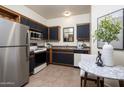 Compact kitchen featuring dark cabinetry, stainless steel appliances, and a charming breakfast nook at 1126 W Elliot Rd # 1024, Chandler, AZ 85224