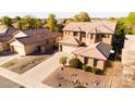 Two-story home features a two-car garage, landscaped front yard, and neutral color scheme at 122 W Raven Dr, Chandler, AZ 85286