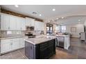 Well-designed kitchen featuring white cabinets, stainless steel appliances, and a dark kitchen island at 122 W Raven Dr, Chandler, AZ 85286