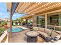 Outdoor patio with built in seating and fire table that overlooks a lovely pool and beautiful backyard at 1275 E Verde Blvd, Queen Creek, AZ 85140