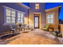 Inviting front patio featuring brick pavers, decorative chairs and table, and colorful potted flowers at 1275 E Verde Blvd, Queen Creek, AZ 85140