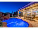 Backyard pool with a waterfall feature and lounge chairs, along with a covered patio and sliding glass doors at 1275 E Verde Blvd, Queen Creek, AZ 85140