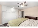 Cozy bedroom features built-in closet space, a ceiling fan, and hardwood floors at 13621 N Emberwood Dr, Sun City, AZ 85351