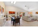 Open-concept living and dining area with vaulted ceilings, tile floors, and sliding glass doors to patio at 17077 N Zuni Trl, Surprise, AZ 85374