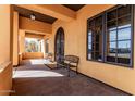 Inviting front porch features cozy seating, decorative ironwork, and warm lighting, perfect for relaxing at 18332 W Latham St, Goodyear, AZ 85338