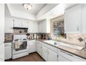 Bright kitchen featuring white cabinetry, tile backsplash, and window over the sink at 25236 S Lakeway Dr, Sun Lakes, AZ 85248