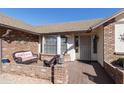 Cozy front porch with brick accents, outdoor seating, and a secure screen door entrance at 2558 E Inglewood St, Mesa, AZ 85213