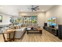 Bright living room with a modern ceiling fan, wood flooring, and a comfortable sectional sofa at 2843 E Los Gatos Dr, Phoenix, AZ 85050