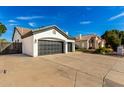 Three-car garage of a charming home with a long driveway and neat landscaping at 328 E Ivy St, Mesa, AZ 85201