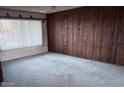 Cozy living room featuring classic wood paneling and ample natural light at 3934 E Sahuaro Dr, Phoenix, AZ 85028