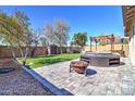 Expansive backyard with lush green lawn, brick-paved patio area, fire pit, and spa, perfect for outdoor entertaining at 40716 N Hudson Trl, Anthem, AZ 85086