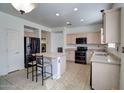 Spacious kitchen with a large center island, sleek black appliances, neutral cabinetry, and tile floors at 40716 N Hudson Trl, Anthem, AZ 85086