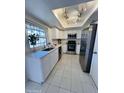 Modern kitchen with stainless steel appliances, white cabinets, and ample countertop space at 4765 W Mediterranean Dr, Glendale, AZ 85301