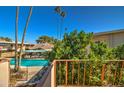 Balcony view showcasing the community pool surrounded by lush greenery and palm trees at 520 W Clarendon Ave # E18, Phoenix, AZ 85013