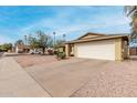 View of the home featuring a front yard and a two-car garage and driveway at 5226 W Freeway Ln, Glendale, AZ 85302