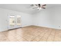 A bright living room featuring tiled floors, a ceiling fan, and access to the backyard at 5226 W Freeway Ln, Glendale, AZ 85302