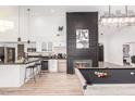 Modern kitchen and living area featuring granite counters, stainless steel appliances, and a game room at 6601 E Hearn Rd, Scottsdale, AZ 85254