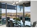 Chic dining area with a glass table, sleek chairs, and a picturesque city and mountain view at 7180 E Kierland Blvd # 508, Scottsdale, AZ 85254