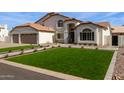 Charming two-story home featuring a three-car garage, manicured lawn, and beautiful desert landscaping at 951 N Poinciana Rd, Gilbert, AZ 85234