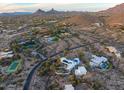Aerial view of desert community featuring luxury homes, pools, and a tennis court amidst natural landscape at 10029 E Calle De Las Brisas --, Scottsdale, AZ 85255