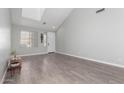 Bright living room with neutral walls, high ceilings, and wood-look tile floors at 11851 W Alvarado Rd, Avondale, AZ 85392