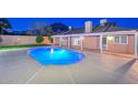 An illuminated backyard pool at night with an inviting glow and patio at 13014 N 23Rd Pl, Phoenix, AZ 85022