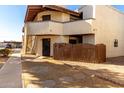 Exterior view of a two-story condo featuring neutral stucco, a private gated patio, and stairs to the upper unit at 16402 N 31St St # 102, Phoenix, AZ 85032