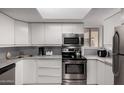 Well-lit kitchen with stainless steel appliances, white cabinets, gray countertops, and a window at 16402 N 31St St # 102, Phoenix, AZ 85032