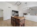 Kitchen showcases a butcher block island, stainless steel fridge, and decorative lighting at 17201 N Chance Dr, Surprise, AZ 85374