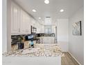 Bright kitchen with white cabinetry, granite counters, and stainless steel appliances at 19700 N 76Th St # 2044, Scottsdale, AZ 85255