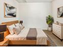 Cozy bedroom with light wood furniture, neutral bedding, and modern artwork at 2181 W Harmont Dr, Phoenix, AZ 85021