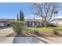 Inviting home with a well-kept lawn, mature landscaping, and an attached garage at 2505 E Hampton Ave, Mesa, AZ 85204