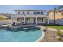 A view of the refreshing backyard pool complete with stone accents, lounge chairs and covered patio at 2506 E Bridgeport Pkwy, Gilbert, AZ 85295