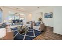 Open-concept living room featuring stylish furniture, a modern rug, and seamless flow to the dining area at 2730 W Via Calabria St, Phoenix, AZ 85086