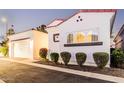 Single-story stucco home with red tile roof, arched windows, manicured shrubs, and a two-car garage at 2777 W Queen Creek Rd # 9, Chandler, AZ 85248