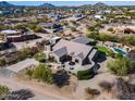 Beautifully landscaped desert home showcasing a circular driveway, firepit, pool, and mountain views at 29618 N 144Th Way, Scottsdale, AZ 85262