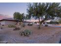 Desert home at dusk with beautiful desert landscaping including cactus and native trees at 36801 N Long Rifle Rd, Carefree, AZ 85377