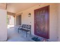 Covered front porch featuring a decorative security door and a charming bench at 5445 S 239Th Dr, Buckeye, AZ 85326